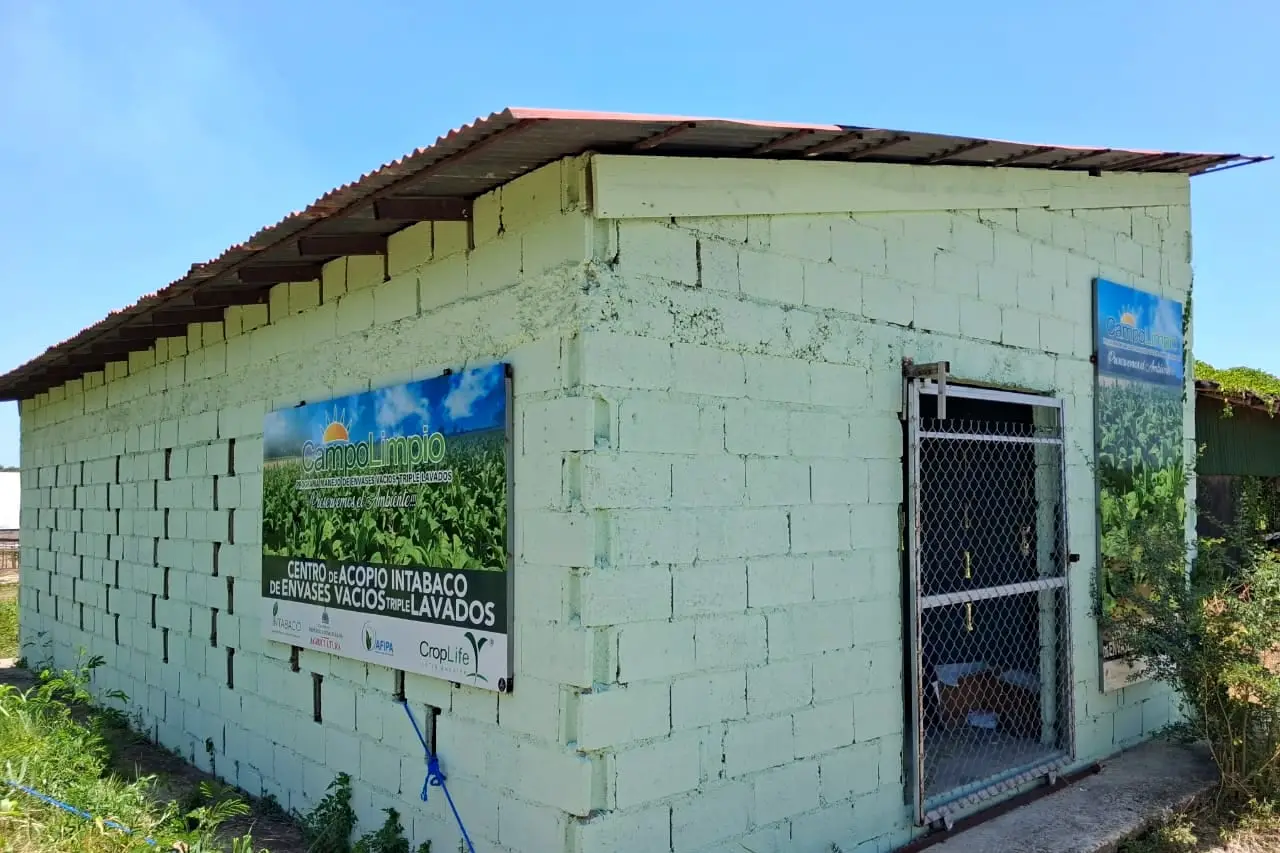 Caseta de bloques del centro de acopio de Intabaco, en Villa González, con letreros de Campo Limpio y una puerta de malla